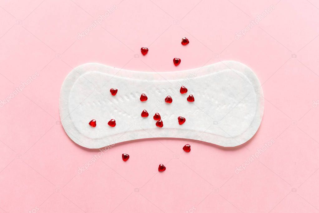 Feminine hygiene pad on a pink background. Concept of feminine hygiene during menstruation. top view.