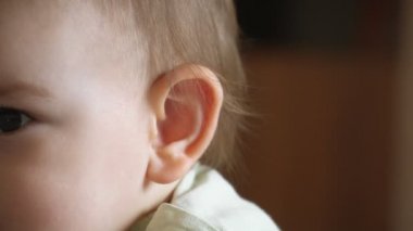 Mutlu bebek bebek kameraya bakıyor ve mutlu bir şekilde gülümsüyor, portreyi kapat, sevimli çocuk