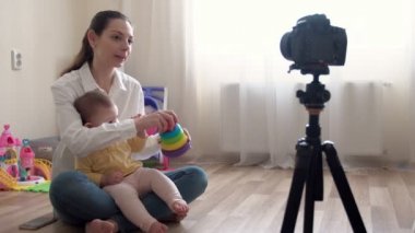Küçük çocuğu olan genç bir anne kameraya video kaydediyor ve aile ve çocukluk hakkında video kaydediyor.