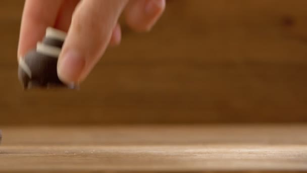 Hand made chocolate candies puting on wooden table womans hands studio — Stock Video