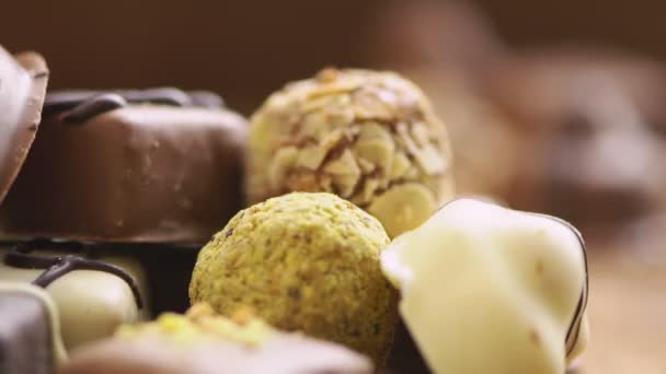 Doces de chocolate feitos à mão caindo no fundo de madeira, doces saborosos em câmera lenta — Vídeo de Stock