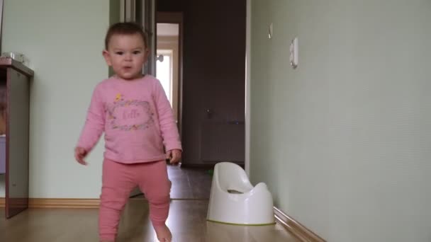 Primeiros passos da criança bebê aprendendo a andar na sala de estar. Cair e levantar-se — Vídeo de Stock