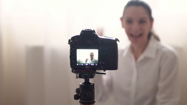 Привлекательная кавказка известная блоггер записывает видео для своего онлайн-блога, используя камеру дома — стоковое видео