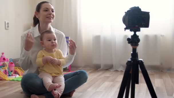 Молода мати з маленьким хлопчиком записує відео на камеру і веде блог про сім'ю і дитинство — стокове відео