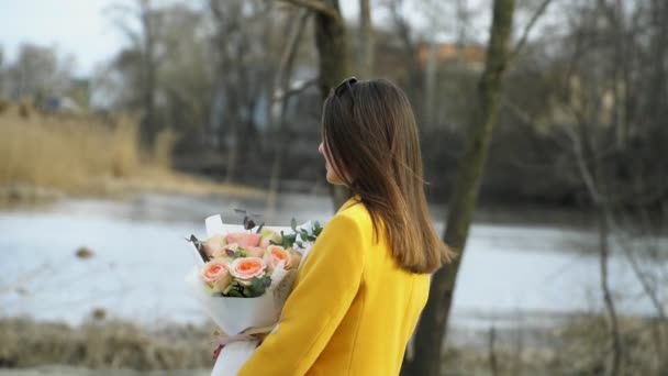 Portré lány sétál a folyón strand virágokkal, kapcsolat kemény koncepció a szabadban — Stock videók