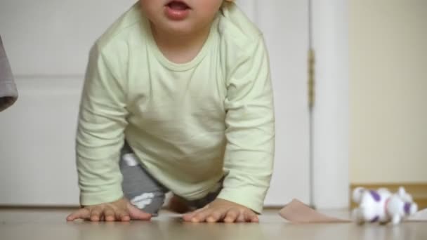 Close-up of childrens legs taking their first steps and falling down — Stock Video