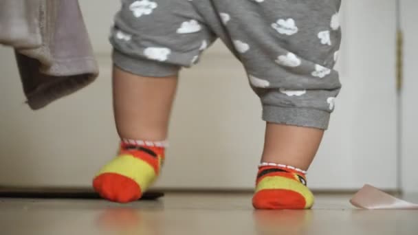 Primo piano delle gambe dei bambini che fanno i loro primi passi e cadono — Video Stock