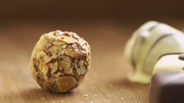 Ruční čokoládový kanystr padá na dřevěné pozadí, chutné sladkosti v pomalém pohybu UHD — Stock video