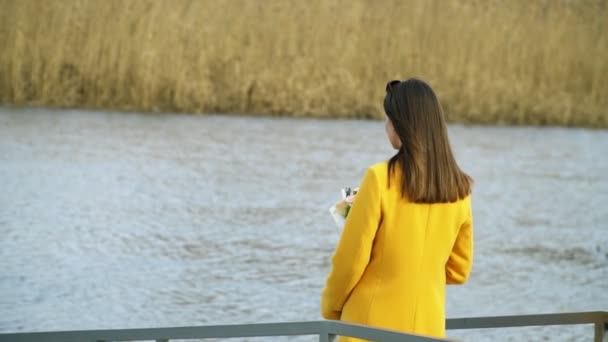 Портрет девушки, гуляющей по берегу реки с цветами, отношения жесткая концепция на открытом воздухе — стоковое видео