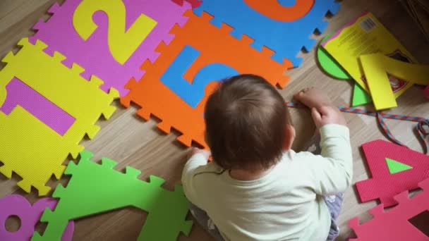Ragazza bambino sul pavimento ht efloor a casa a giocare con puzzle stuoia di schiuma con i numeri, lo sviluppo precoce — Video Stock