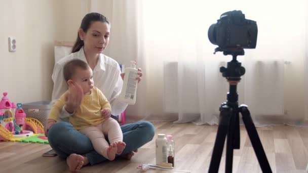 Madre joven con un niño pequeño grabando video en la cámara y vlogging sobre la familia y la infancia — Vídeos de Stock