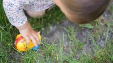 Plastik araba oyuncakları, çocukluk aktivitesi ile açık havada oynarken elbise küçük bir kız yürümeye başlayan veya bebek