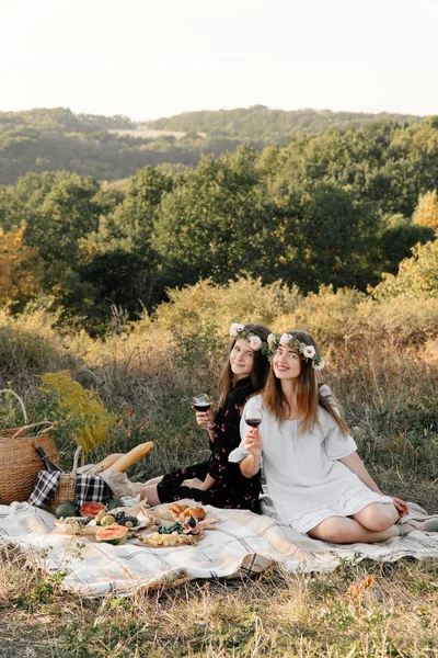 Two best friends on picnic in the field laying on the laid smiling