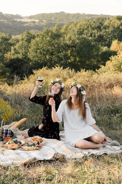 Two best friends on picnic in the field laying on the laid smiling