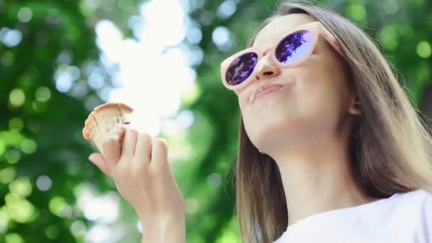 Κοντινό πλάνο καλοκαιρινό φόντο. Νεαρή γυναίκα τρώει παγωτό — Αρχείο Βίντεο