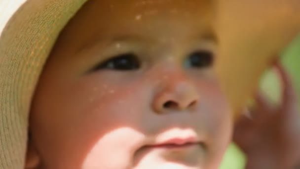 Портрет маленькой девочки в платье и соломенной шляпе на улице днем, солнечная погода hd — стоковое видео