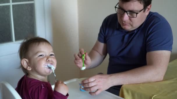 父亲在家里用勺子4k 喂养可爱的小女儿 — 图库视频影像