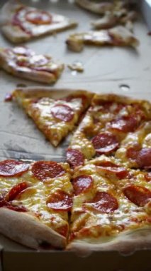Pizza dikey formatta paket karton üzerinde parçalara kesilmiş, 4k