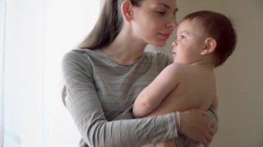 Mutlu neşeli bir aile. Anne ve bebek öpüşme, gülme ve 4k sarılma