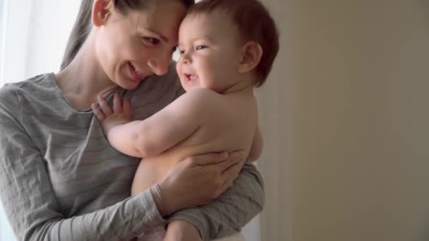 Mère tient bébé tout-petit à la maison avec amour et douceur. Concept de maternité 4k — Video