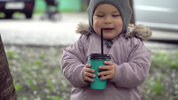 Ritual de la mañana, bebé pequeño afuera con taza de papel bebiendo café con chocolate 4k — Vídeos de Stock