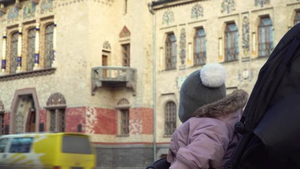 Portret van schattig een kind in een kinderwagen op straat. Europese straten, reizen naar oude plaatsen. Levensstijl — Stockvideo