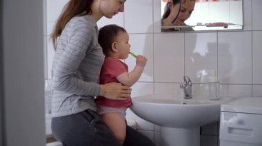 gülümseyen anne ve çocuk oğlu banyoda diş fırçalama