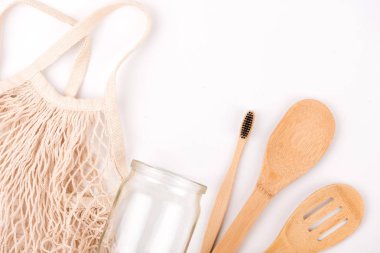 Sıfır atık çevre dostu düz yatıyordu. Beyaz arka plan. Örgü alışveriş çantası, mason kavanoz, bambu diş fırçası