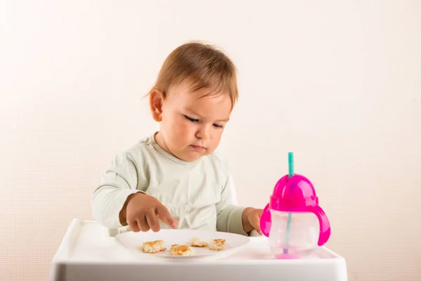 A criança bebê come comida com os dedos. Cara engraçada. Espaço de cópia — Fotografia de Stock