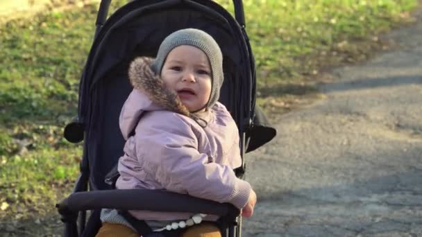 Bebé de niño en sombrero gris sentado en cochecito y llorando. cochecito de odio 4k — Vídeos de Stock