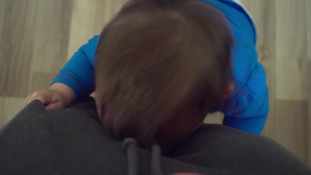 Vista superior del retrato de bebé muy emocional sostiene las piernas de las madres — Vídeos de Stock