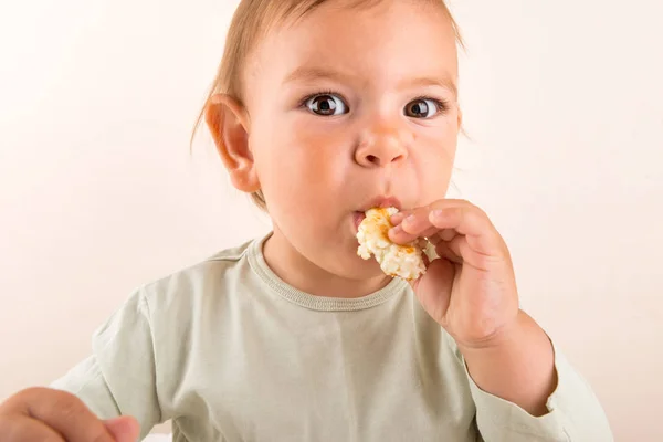 A criança bebê come comida com os dedos. Cara engraçada. Espaço de cópia — Fotografia de Stock