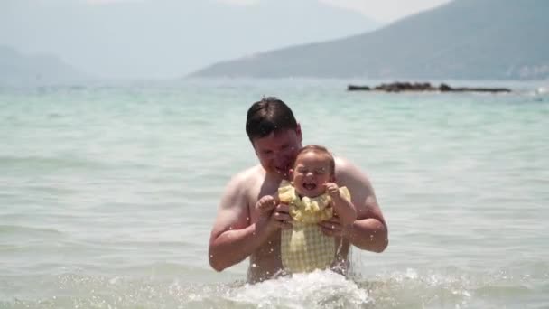 Padre e bambina in costume da bagno giallo che giocano in mare. Atene Grecia. La paternità — Video Stock