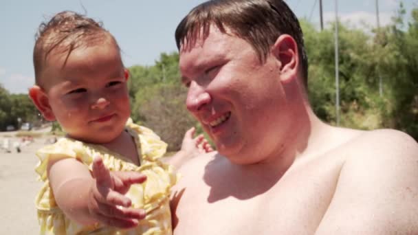 Joven padre riéndose con su pequeña hija al aire libre. Primer plano de padre feliz divirtiéndose con un bebé — Vídeos de Stock