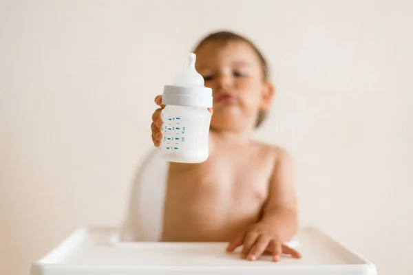 Adorable baby drinking milk from a bottle from bottle. Formula drink for infant. Kitchen — Stock Photo, Image