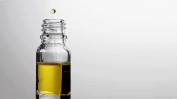 Glasflasche mit Pipette mit ätherischem Öl fällt in Zeitlupe. Natürliche Therapie — Stockvideo