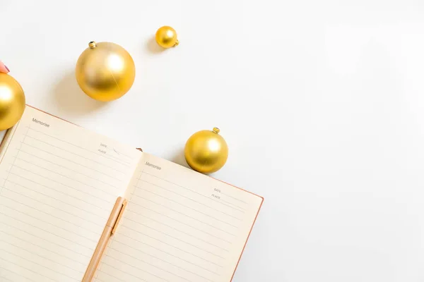 Χριστουγεννιάτικο γραφείο με σημειωματάριο, στυλό και χρυσές μπάλες. 2020 στόχους. Κορυφαία προβολή — Φωτογραφία Αρχείου