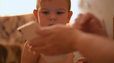 Büyükanne ve büyükbaba ile akıllı telefonda video izlerken bebek kapatın. Yaşlı eğitim teknolojisi.