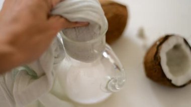 evde vegan hindistan cevizi sütü hazırlayan kadın. Süzülmek için sütü peynir bezinin içine döküyoruz. Alternatif süt