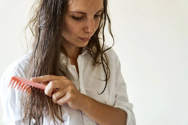 Hermosa mujer cepillando su cabello húmedo desordenado después del baño con peine. Pelo delgado porblem — Foto de Stock