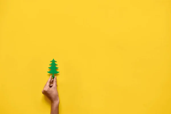 노란색 배경에 플라스틱 장난감 소나무 나무입니다. 크리스마스 시즌의 최소한의 평평한 평신도. 복사 공간 — 스톡 사진