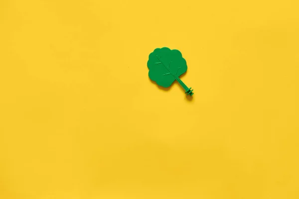 Árbol de madera de juguete de plástico sobre fondo amarillo. Colocación plana mínima de ambiente ecológico —  Fotos de Stock