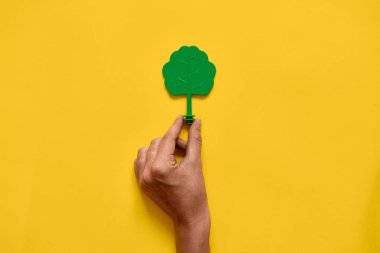 Sarı arka plan üzerinde plastik oyuncak ahşap ağaç. Ekoloji ortamının minimal düz yatıyordu