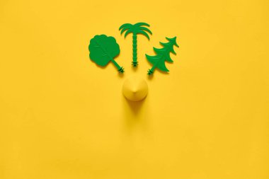 Sarı arka plan düz yeşil ağaçlar kopyalama alanı ile yatıyordu. Çevre ekolojisi fikri