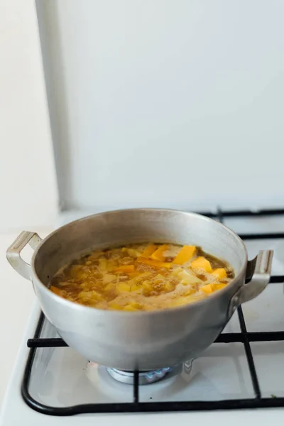 In der Küche auf dem Herd wird die Kürbissuppe in einer Pfanne gekocht. Traditionelle Herbstkost — Stockfoto