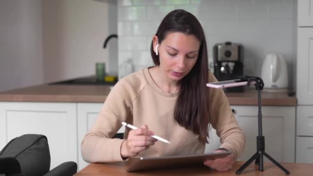 Millennial chica transmitiendo su proceso creativo en la tableta. Influenciador online . — Vídeos de Stock