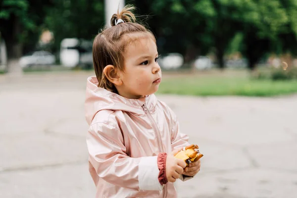 Retrato de niña en impermeable rosa al aire libre. Estilo de vida auténtico retrato —  Fotos de Stock