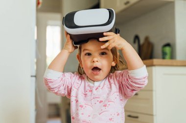 Evde video gözlüklü küçük kız. Öğrenmek, film izlemek, oyunlar oynamak. Gelecekteki teknolojiler