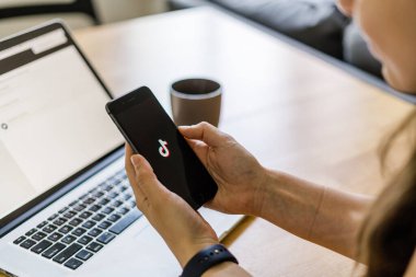 Poltava, Ukrayna - Haziran 2020 Ahşap masada telefon ve üzerinde TikTok logosu.