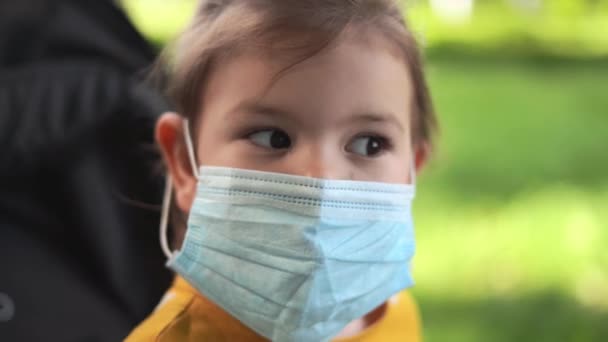 Glückliches Kleinkind Mädchen in medizinischer Maske im Freien. Neuer normaler Sommer 2020. Vorschulkind — Stockvideo
